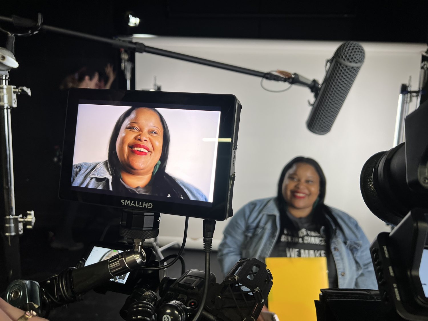 A woman Chelsea coached, smiling with confidence on the camera monitor during her TV debut