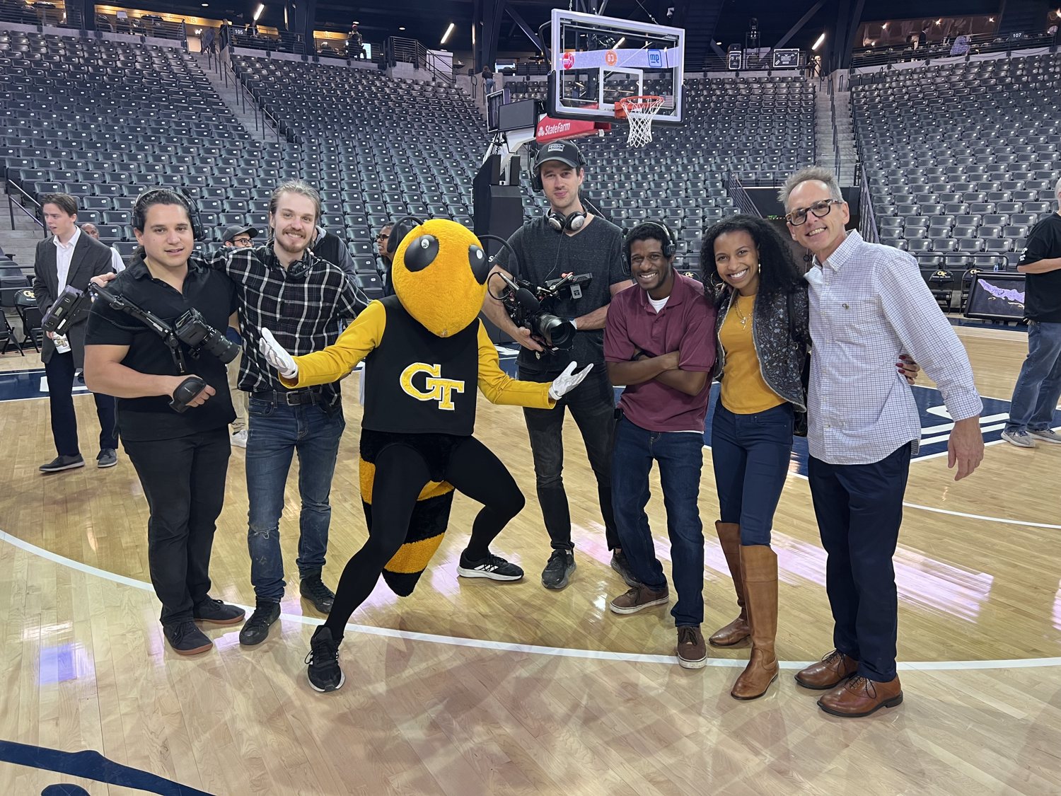 Chelsea with the Georgia Tech mascot, the crew and student inventors on the basketball court for the InVenture Prize