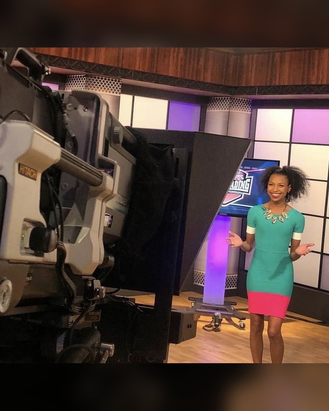 Chelsea on a TV studio set in front of a broadcast camera